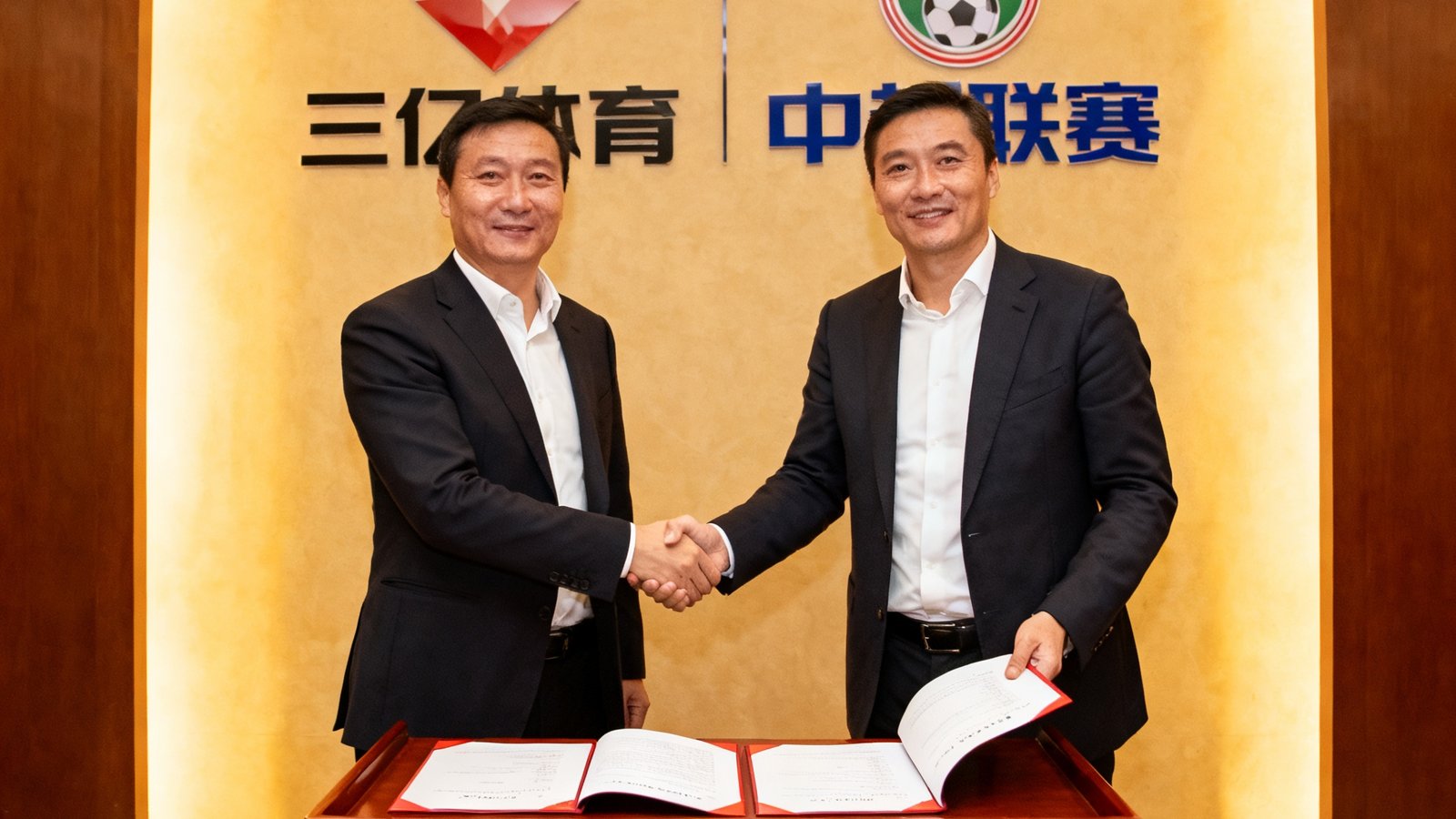三亿体育与中超联赛续约签约仪式现场，双方代表在合作协议上签字并握手合影留念